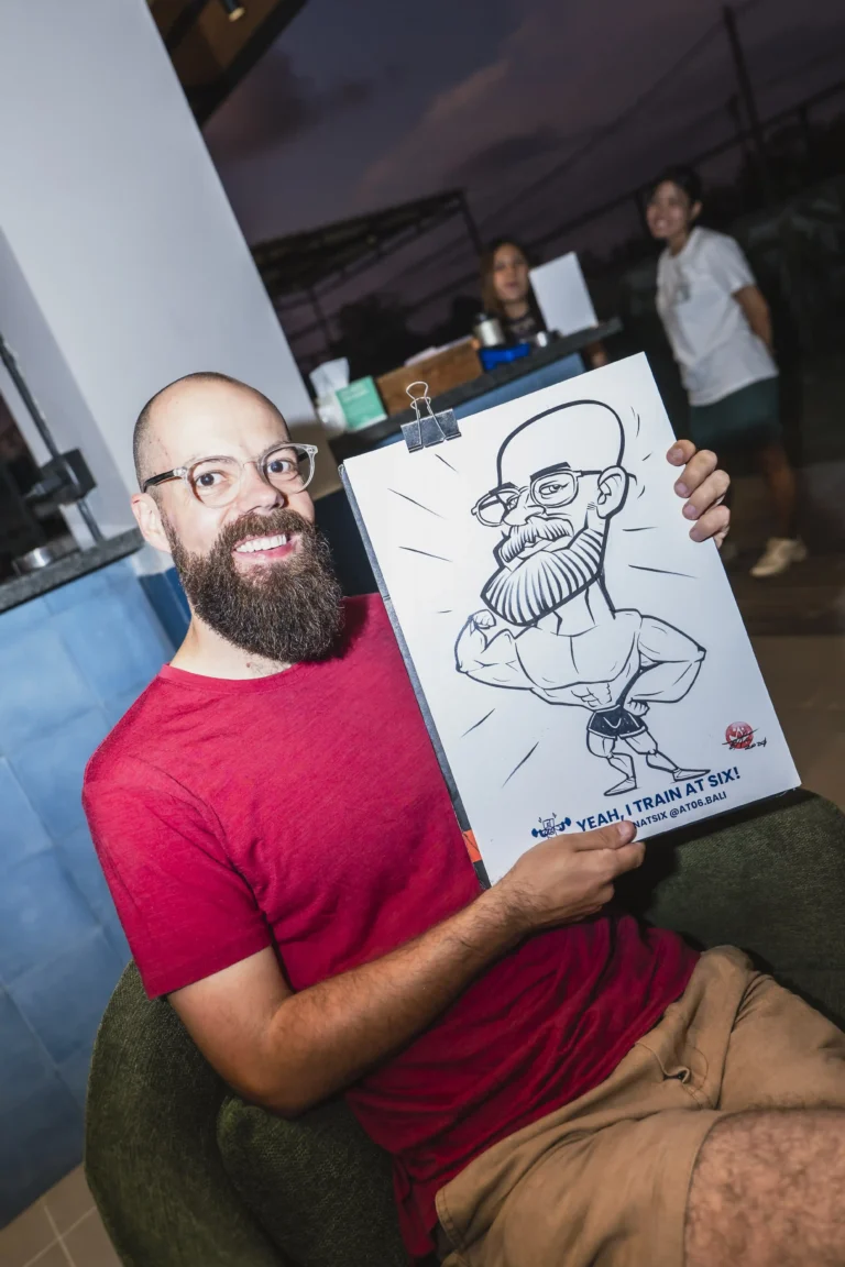 A man proudly showing his caricature from an event at at06 in Canggu.