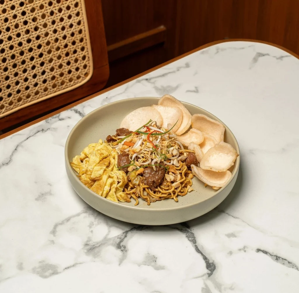 Thai Beef Noodles at AT 06 Canggu Bali with savory noodles, tender beef, egg, and prawn crackers
