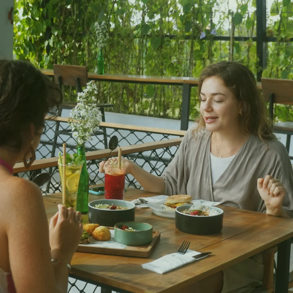 Two friends enjoying a healthy meal and conversation at the at 06 fusion restaurant in Canggu, embodying the community and wellness dining experience in Bali.