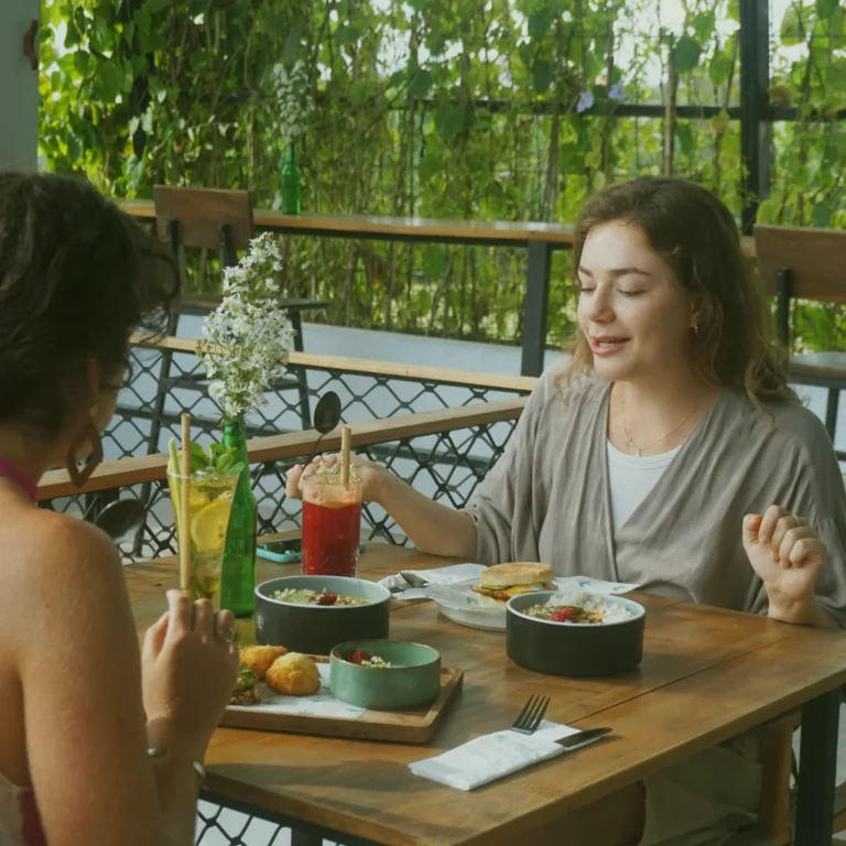 Two friends enjoying a healthy meal and conversation at the at 06 fusion restaurant in Canggu, embodying the community and wellness dining experience in Bali.
