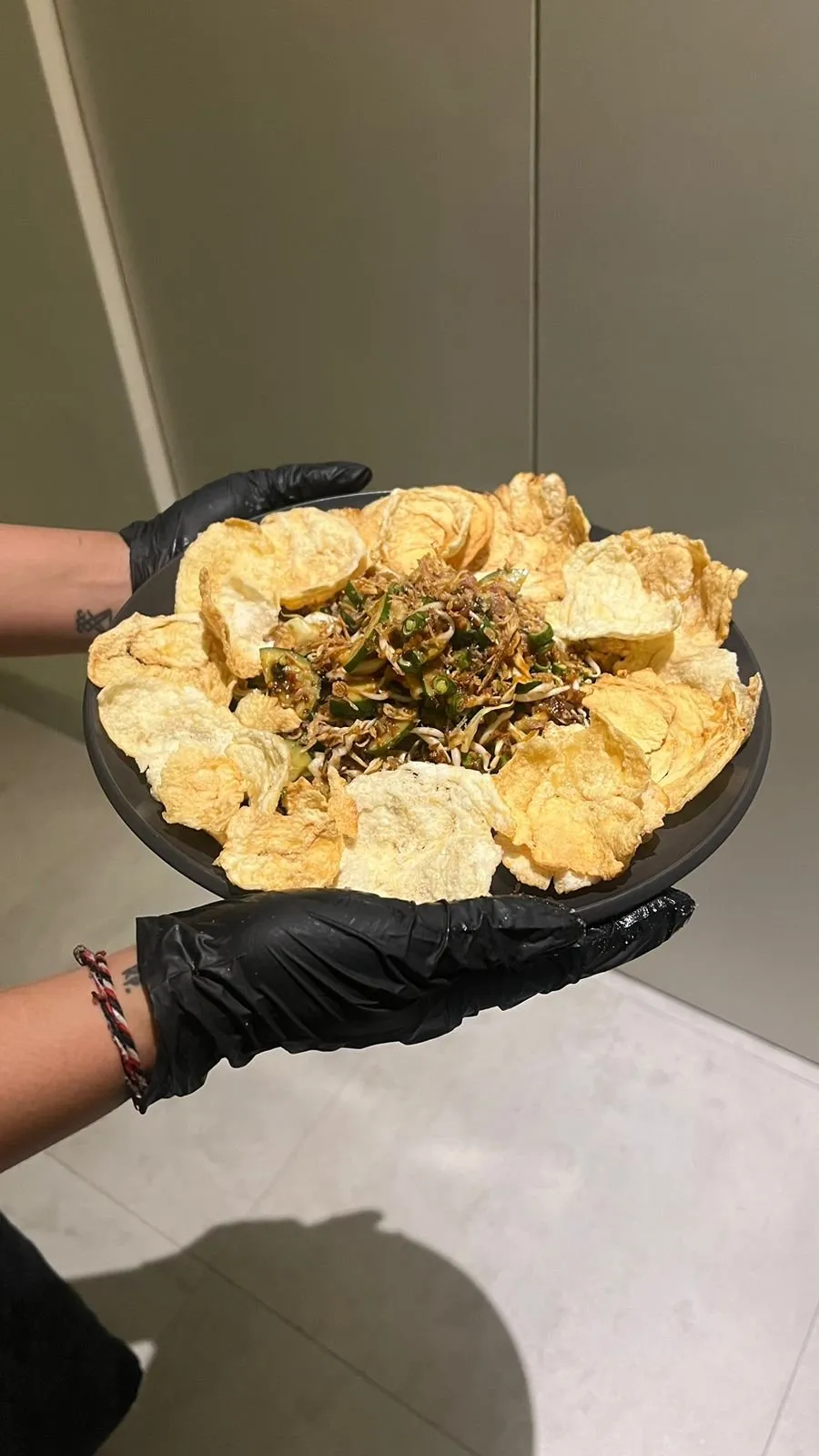 A plate of healthy Asian fusion salad with crackers being served at AT06 restaurant in Canggu.