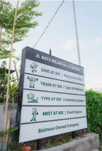 Best Coworking Space in Canggu Bali: AT 06 MBTI Guide 2025 2 The entrance sign for AT06, a multi-concept establishment in Canggu, Bali, highlighting its restaurant, gym, coworking, and event space.
