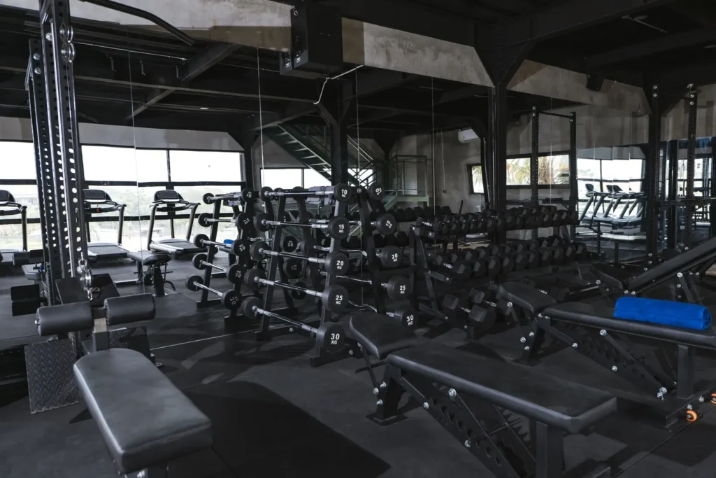 A spacious and well-equipped gym interior with various weight training machines and free weights at at06 in Canggu, Bali.
