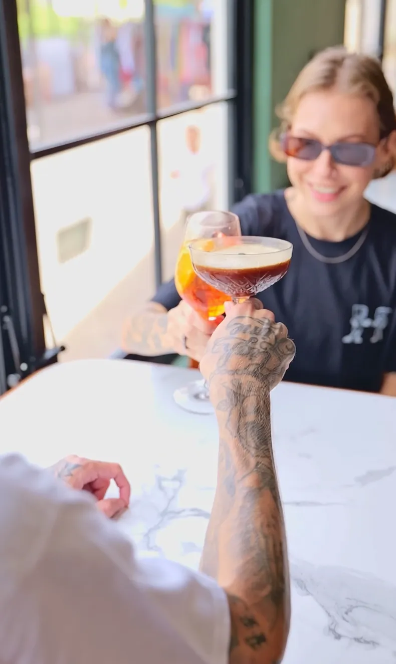 Video thumbnail of two people toasting with cocktails at the at06 cafe.