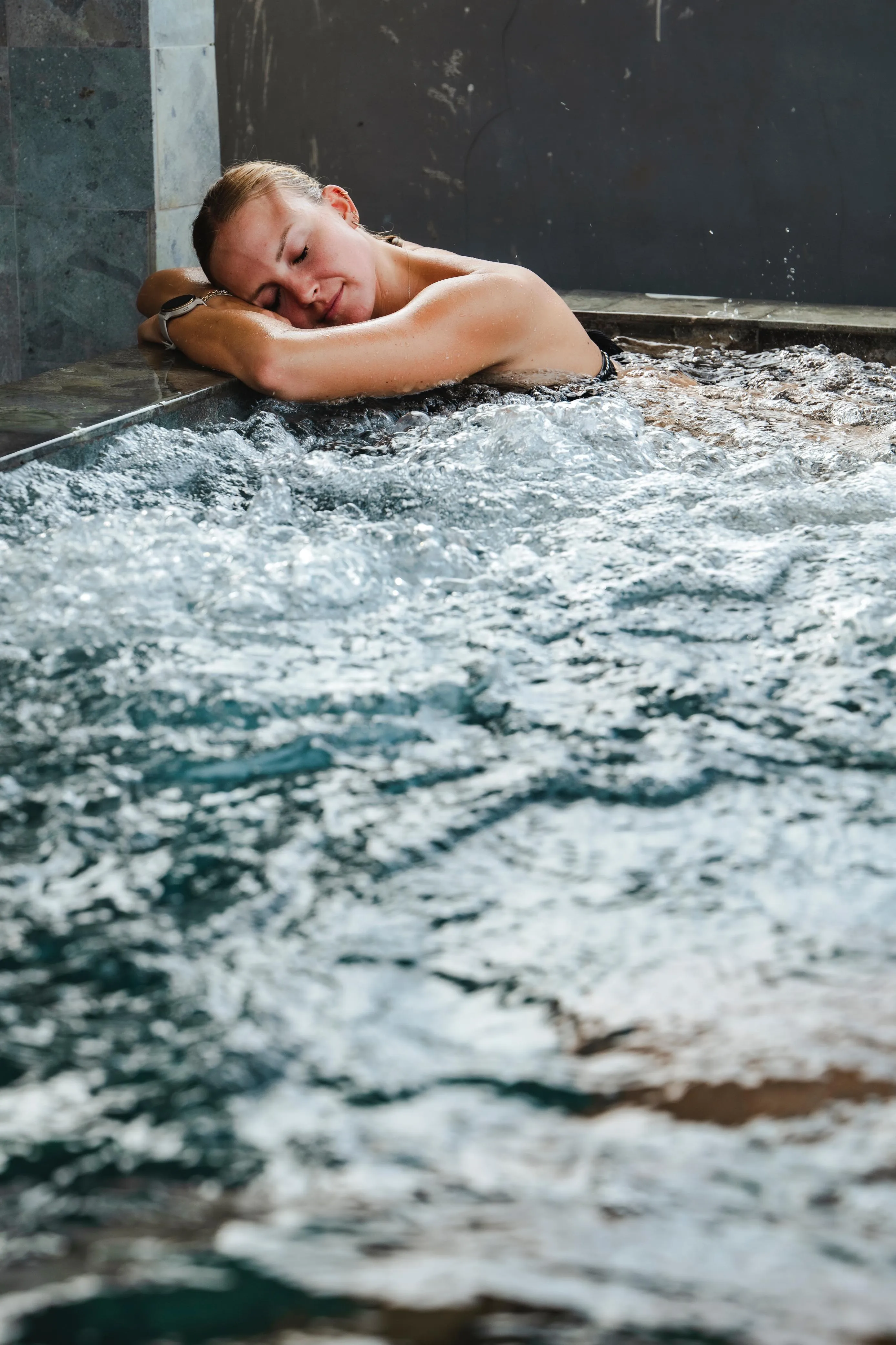 A woman relaxing in a jacuzzi at AT06, a wellness center in Canggu, Bali.