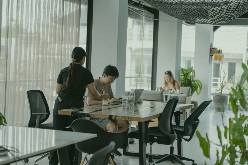 A server assisting a customer at their table in the at06 co-working space in Canggu.