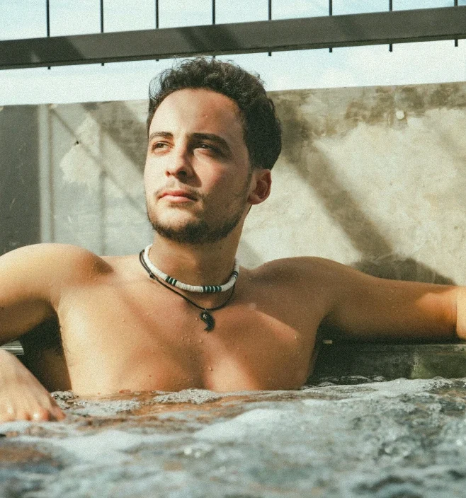 Man relaxing in the cold jacuzzi at AT 06 Canggu Bali under the tropical sun