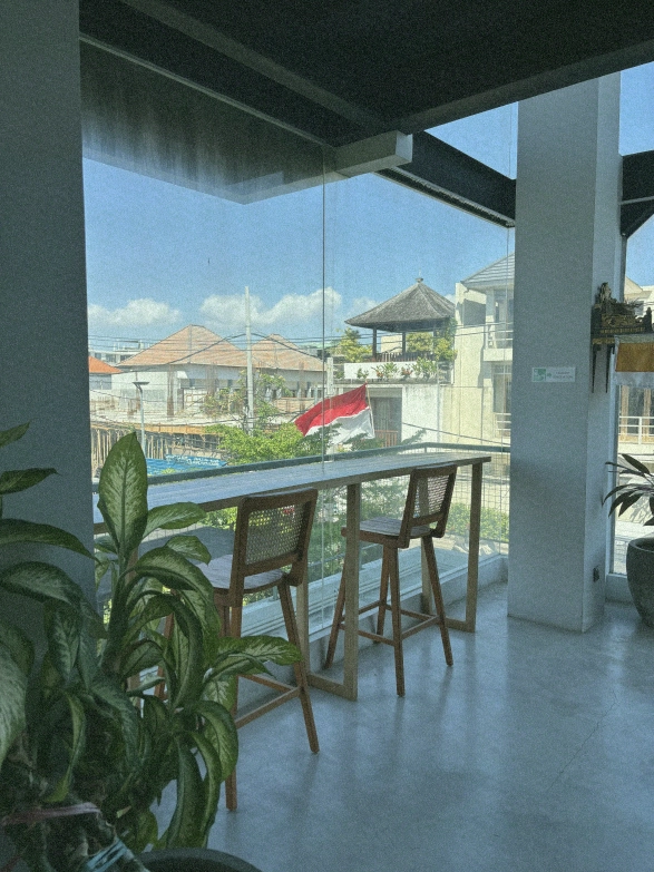 A cozy lounge area in a Canggu coworking space with two armchairs and a view of the neighborhood.